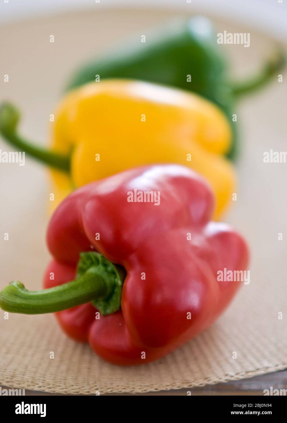 Tre peperoni dolci lucenti, rossi, verdi e gialli - Foto Stock
