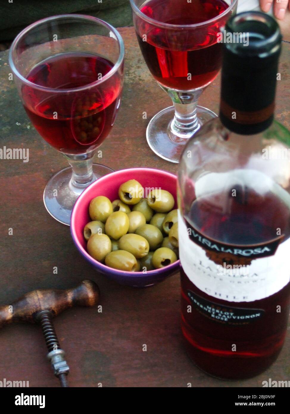 Vino rosato con olivi verdi in giardino la sera d'estate - Foto Stock