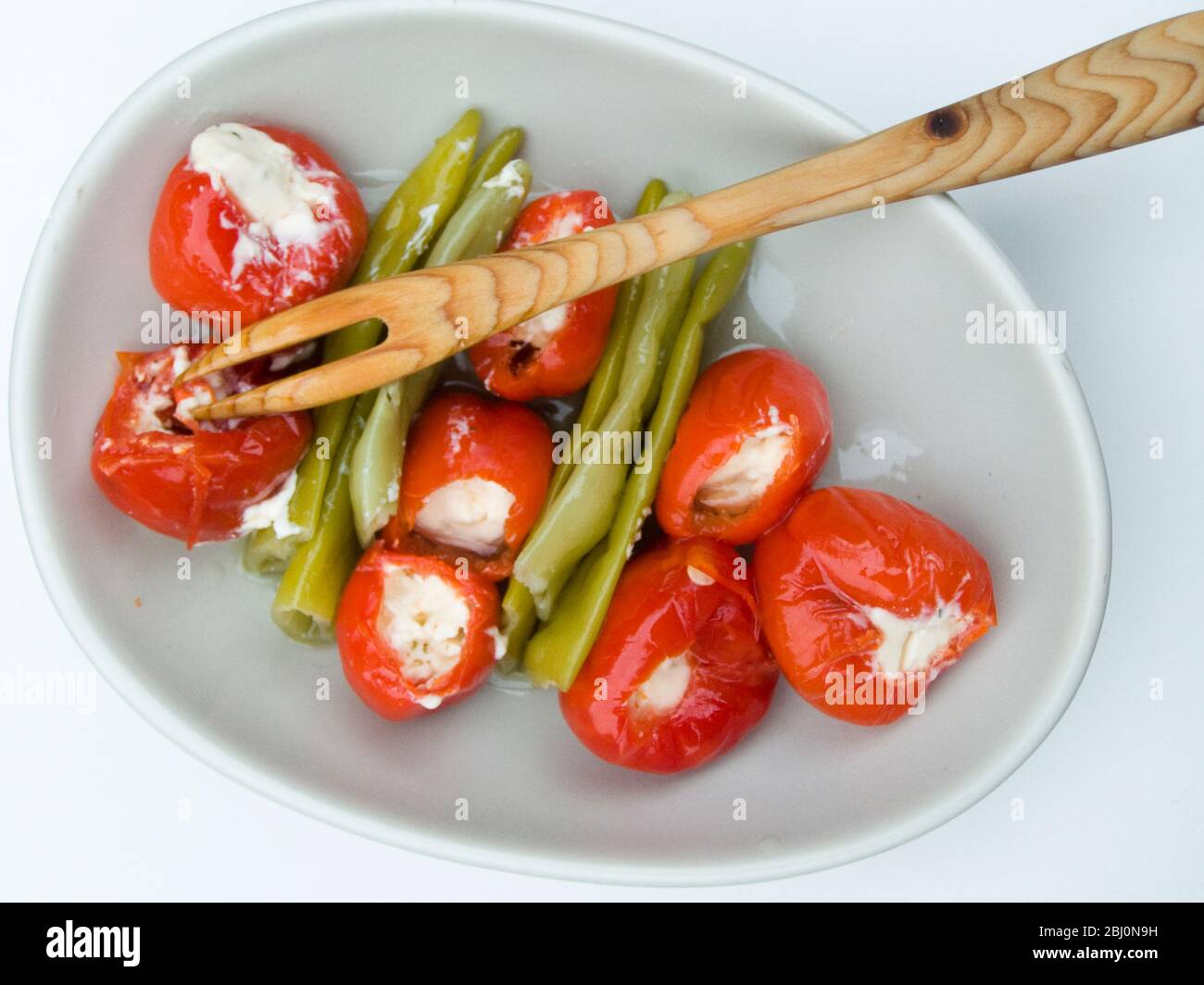 Tapas tipo piatto di peperoni rossi caldi ripieni di formaggio cremoso con peperoncino verde sottaceto - Foto Stock