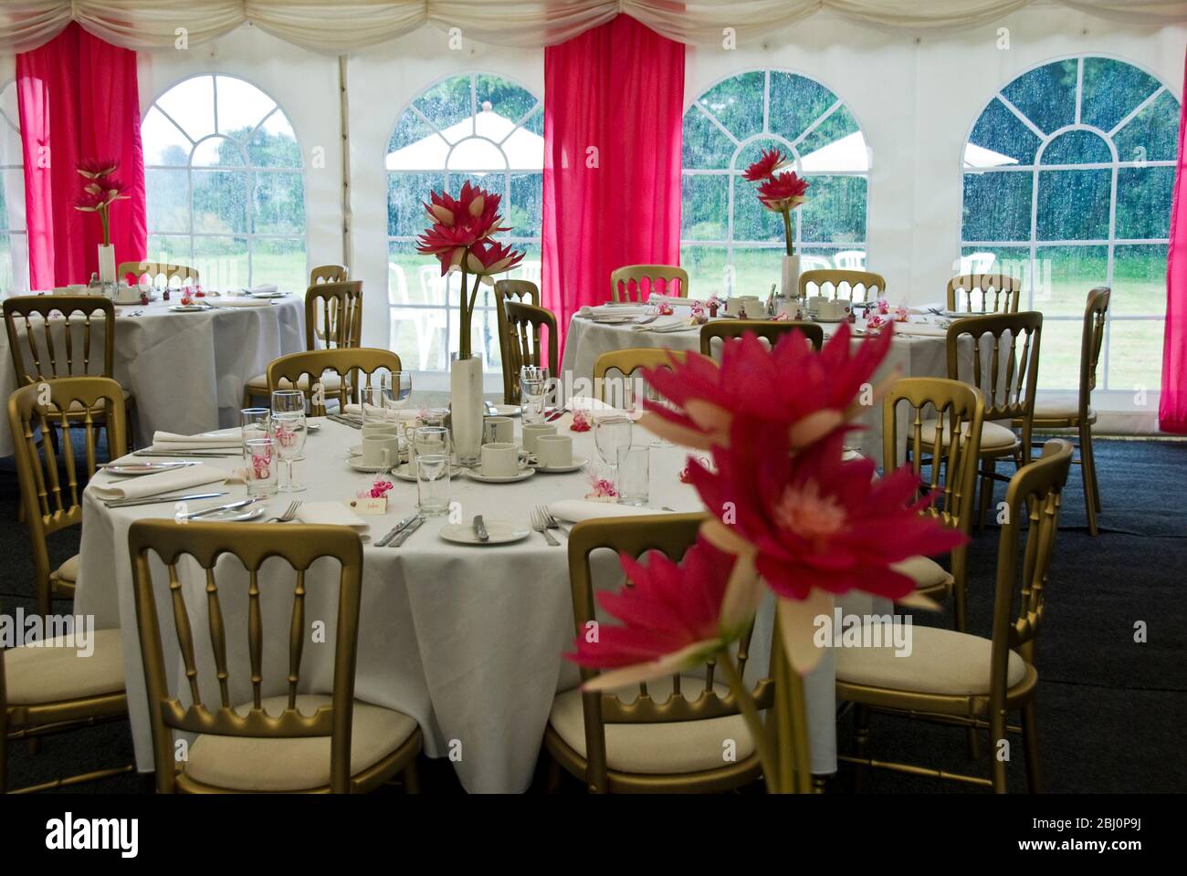 Interno di tendone decorato per un matrimonio estivo in sfumature di rosa e bianco - Foto Stock