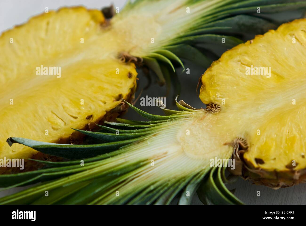 Ananas tagliato a metà su sfondo bianco - Foto Stock