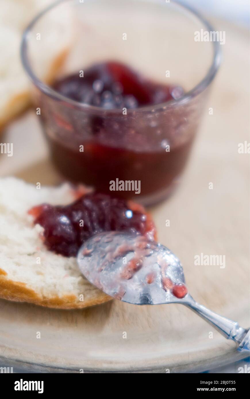 Pane crosty spezzato con dollop di confettura di lamponi senza semi - Foto Stock