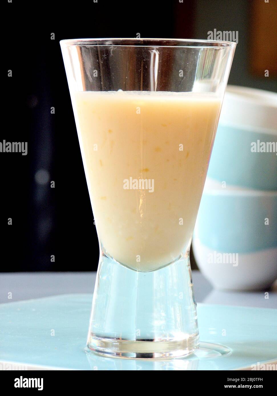 Bicchiere di probiotico, arancio, bevanda in cucina - Foto Stock