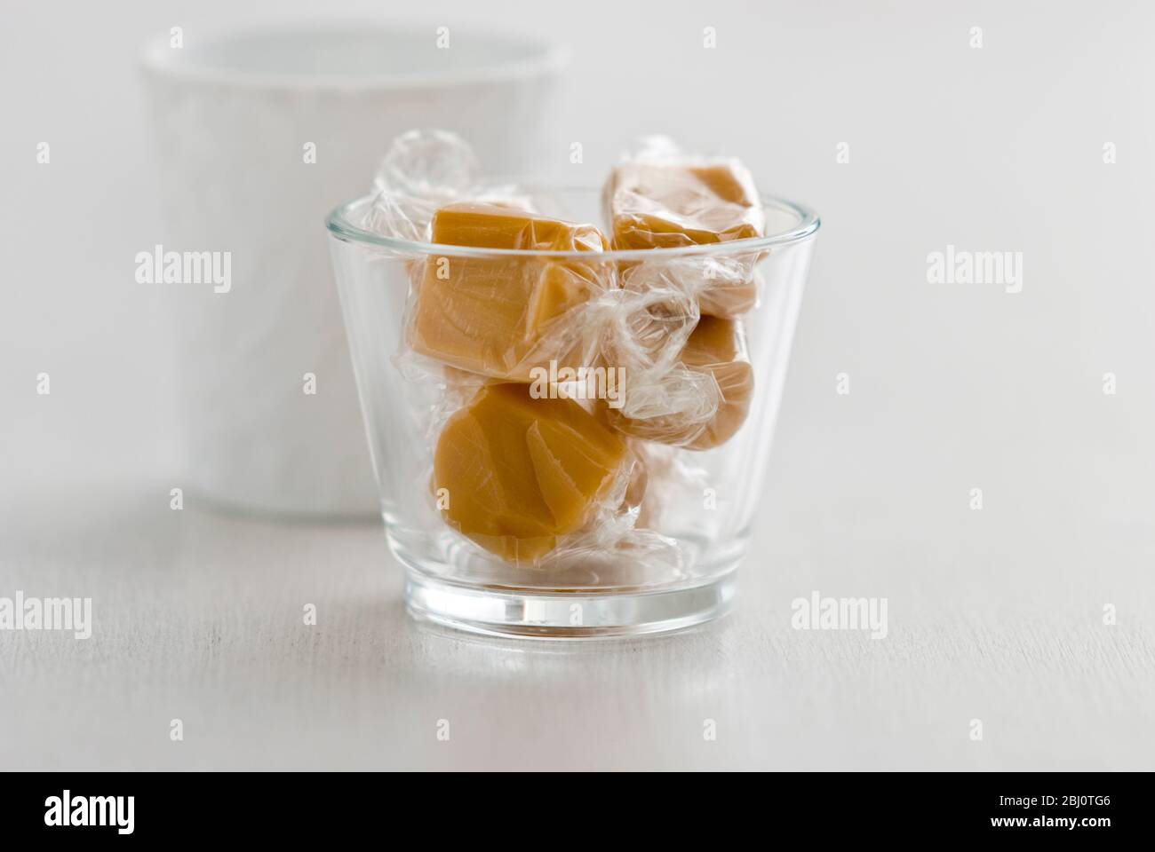 Qualche caramella avvolta in cellophane in una pentola di vetro - Foto Stock