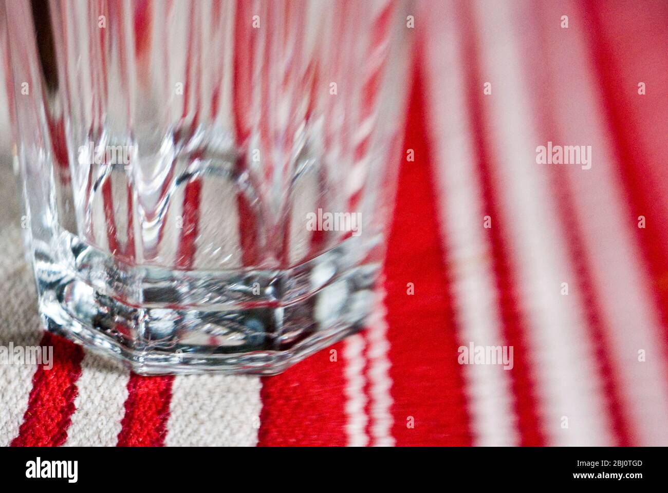 Bicchiere vuoto sul canale del tavolo a righe. - Foto Stock