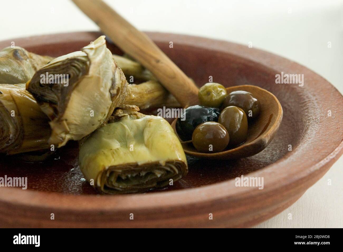 Carciofi italiani alla griglia e marinati su piatto marrone - Foto Stock
