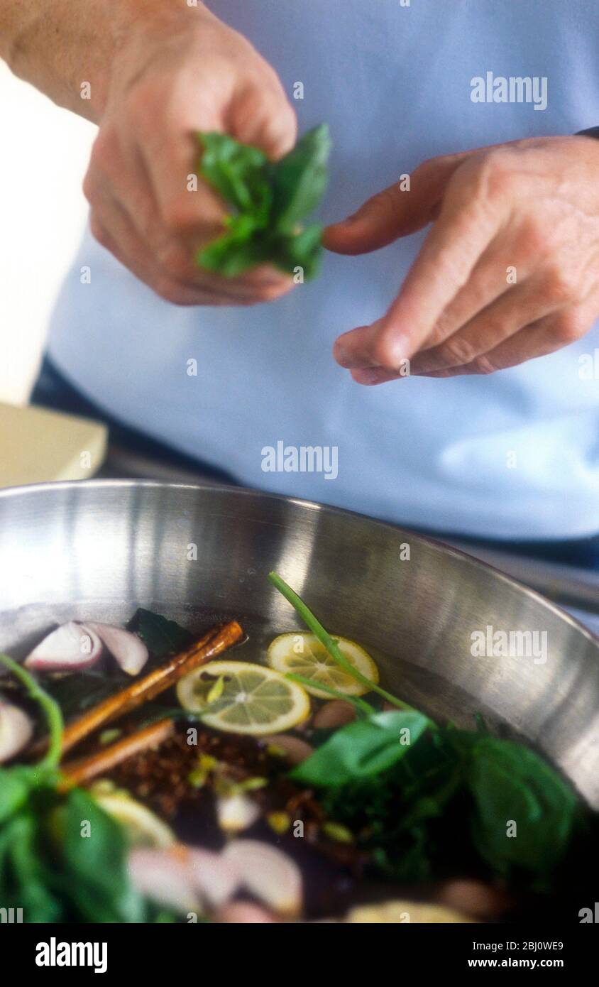 Gordon Ramsay fare un'acqua aromatizzata per cuocere il salmone - Foto Stock