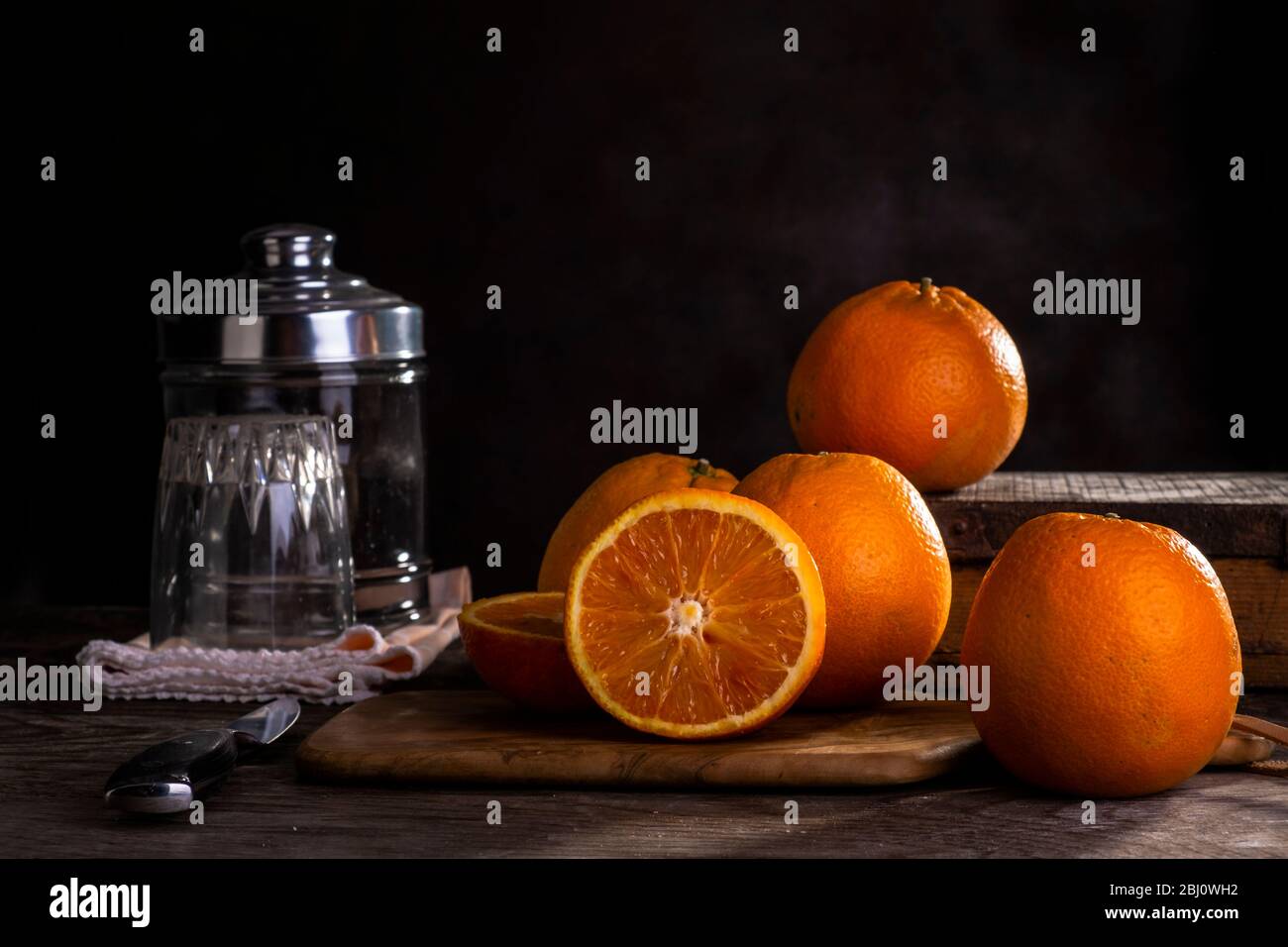 Arance su tavolo di legno con sfondo scuro Foto Stock