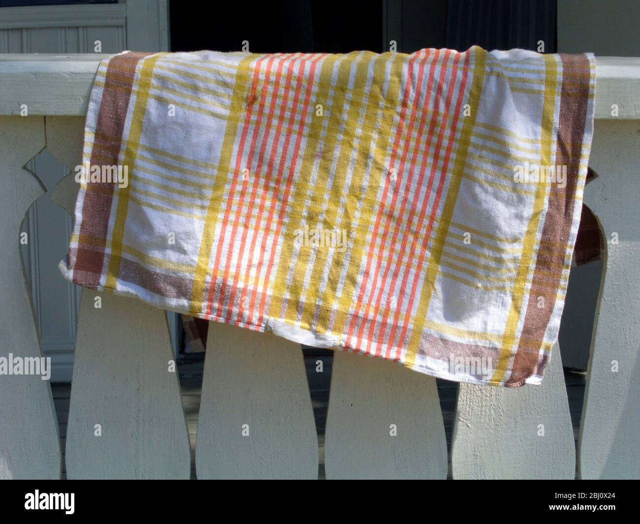Asciugamano da tè attraverso balaustra che asciuga in luce del sole appled - Foto Stock