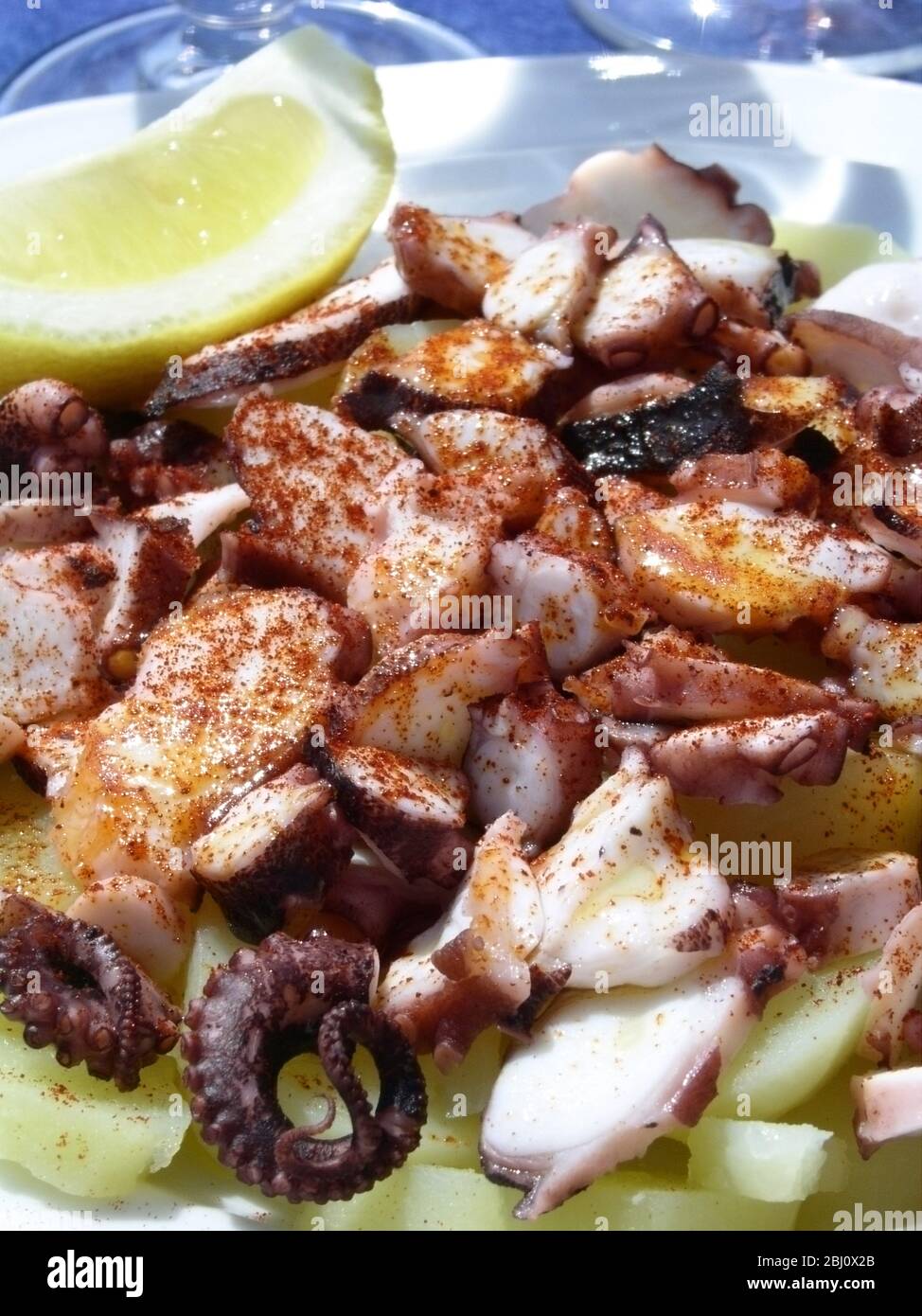 I pezzi fritti di calamari serviti su insalata di cimbera con un cuneo di limone, al ristorante a Menton, nel sud della Francia - Foto Stock