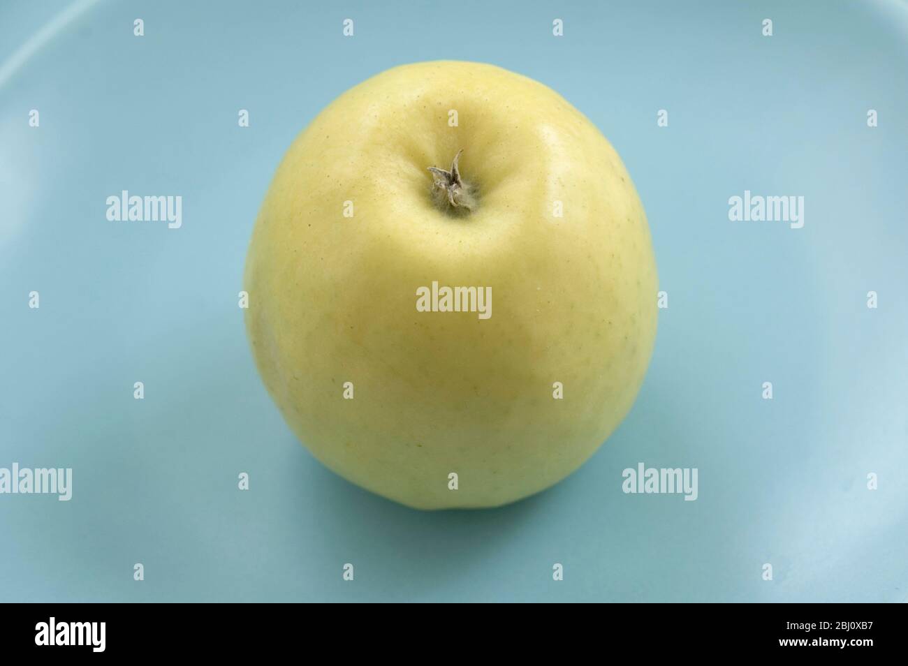 Mela verde gialla su piatti blu - Foto Stock