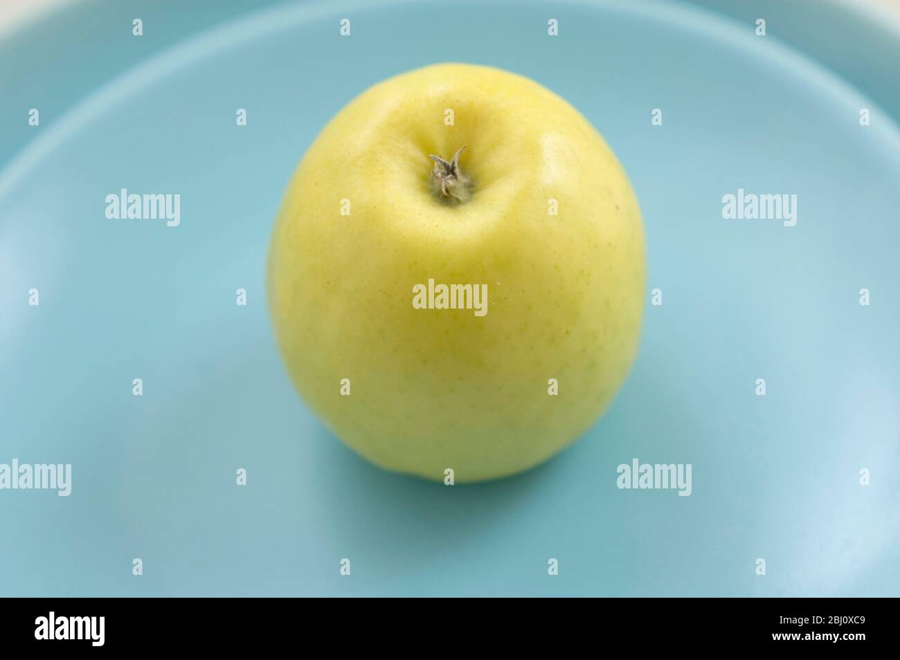 Mela verde gialla su piatti blu - Foto Stock