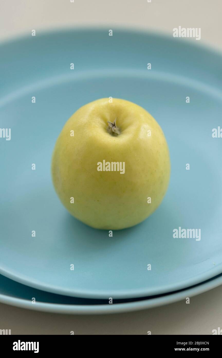 Mela verde gialla su piatti blu - Foto Stock