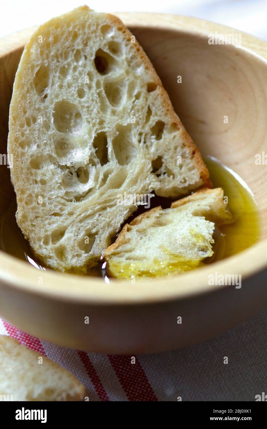 Olio extra vergine di oliva con pane rustico da immergere in esso - Foto Stock