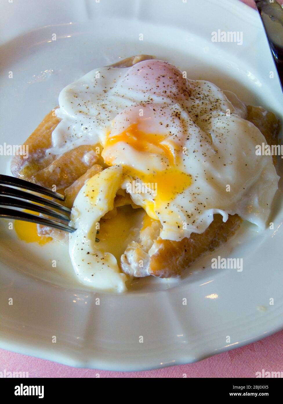 Uovo in camicia su eglefino su piatto bianco - Foto Stock