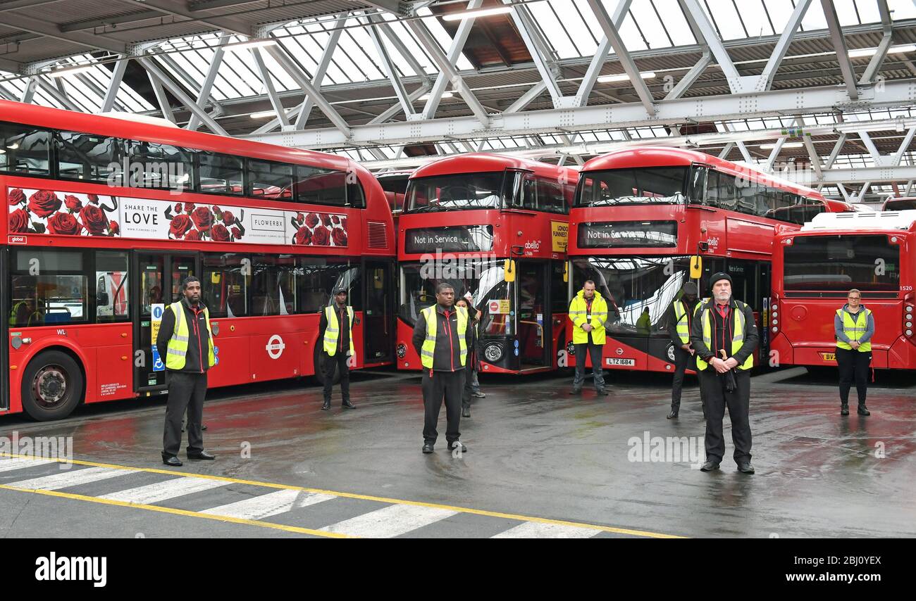 Il personale si trova all'interno del deposito degli autobus di Camberwell a Londra, durante un minuto di silenzio per rendere omaggio al personale dell'NHS e ai principali lavoratori morti durante l'epidemia di coronavirus. Foto Stock