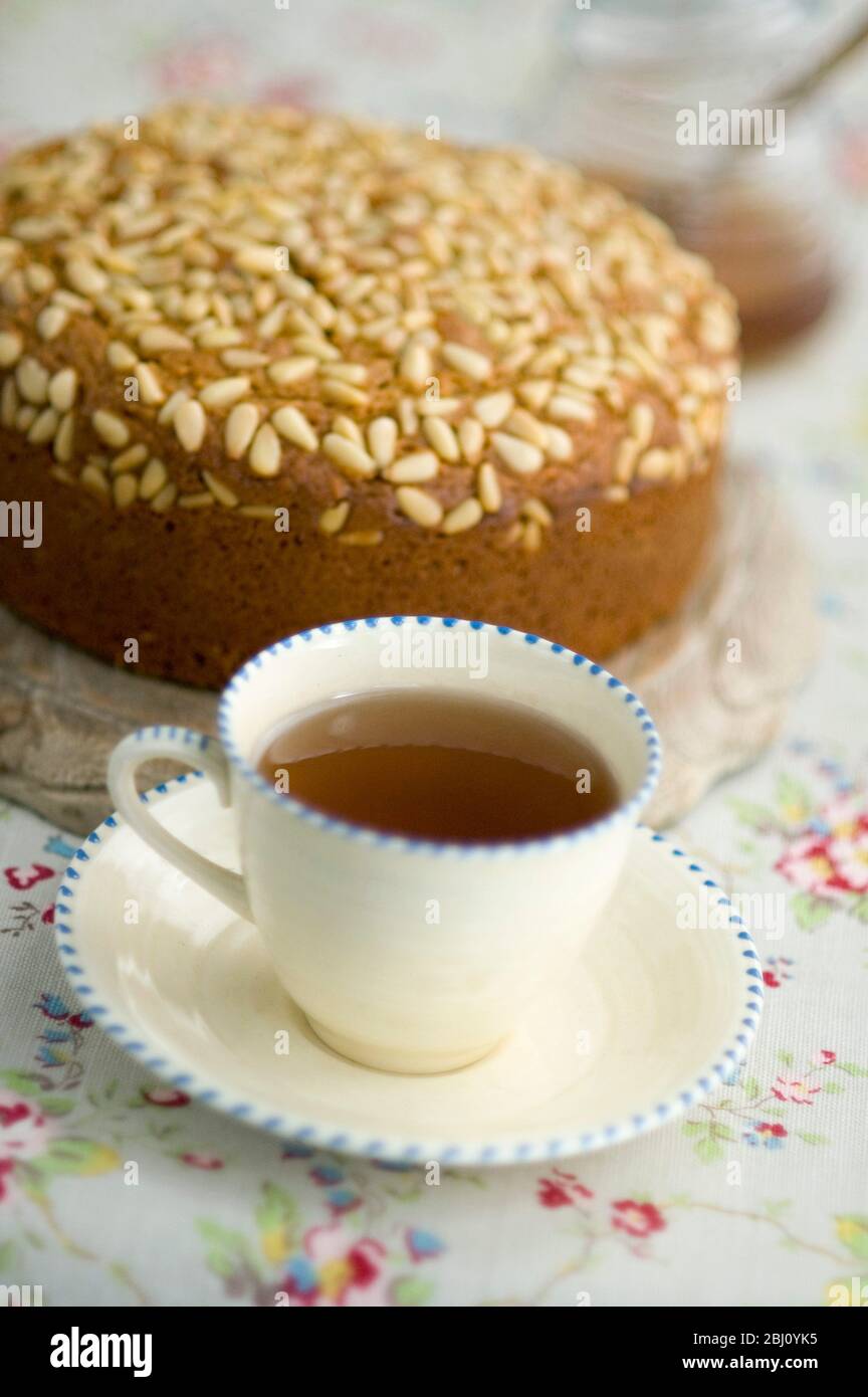 Tazza di tè grigio earl in panna cina senza latte e con torta al pino sullo sfondo - Foto Stock