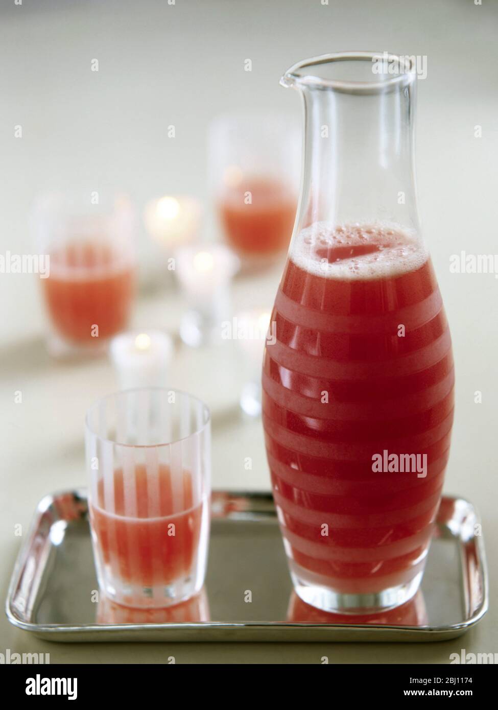 Punch di frutta o frullato in elegante decanter e vetro su vassoio argento - Foto Stock