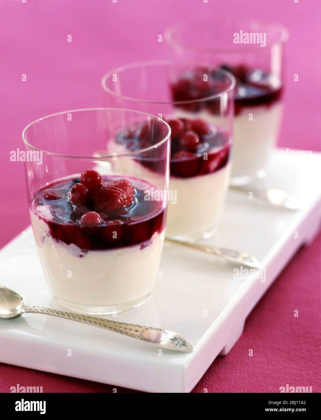 Tre bicchieri di junket alla vaniglia classica con frutta fresca - Foto Stock