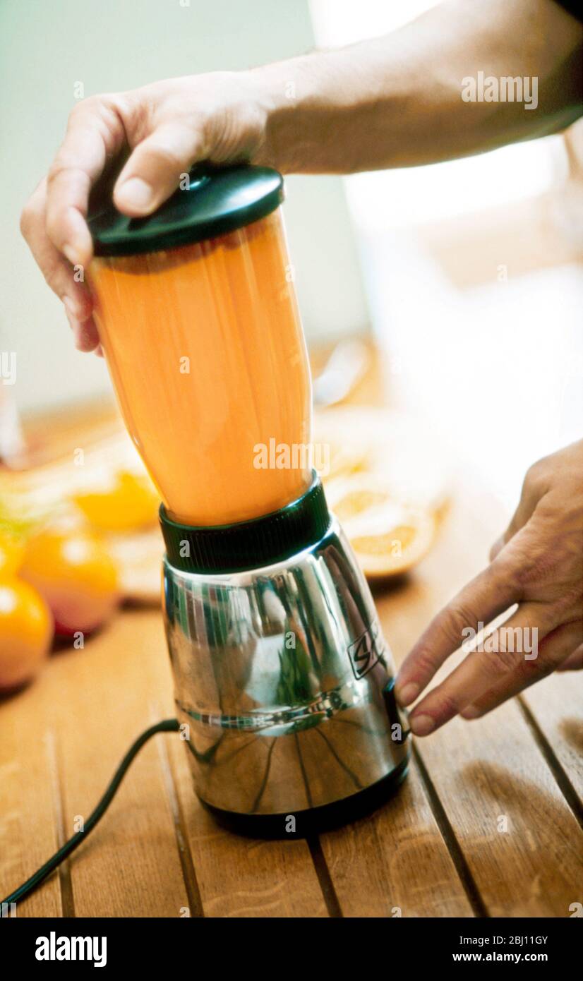 Frullatore smoothie in cromo madein, tenuto dalle mani dell'uomo - Foto Stock