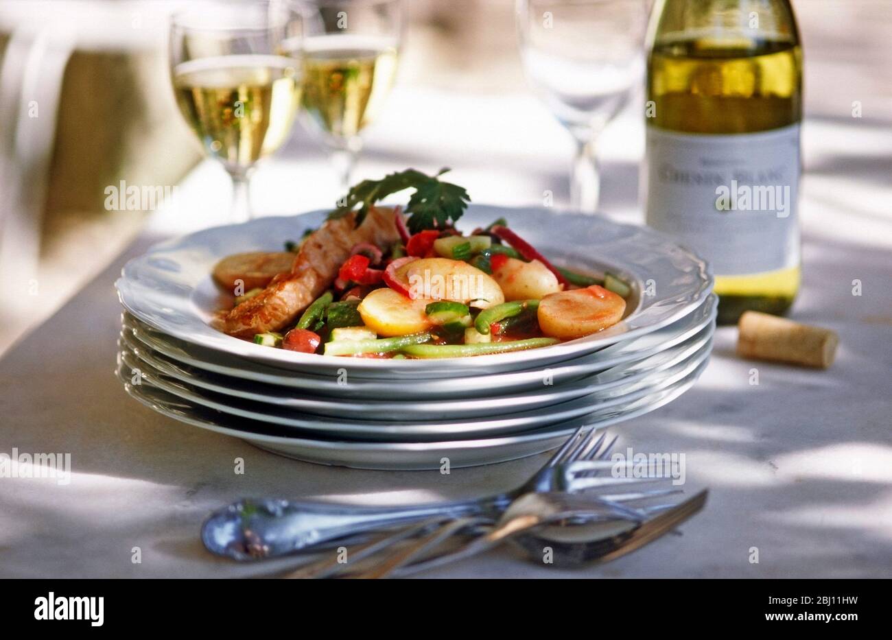Festa estiva all'aperto nel sud della Francia. Pile di piatti con pesce e verdure - Foto Stock