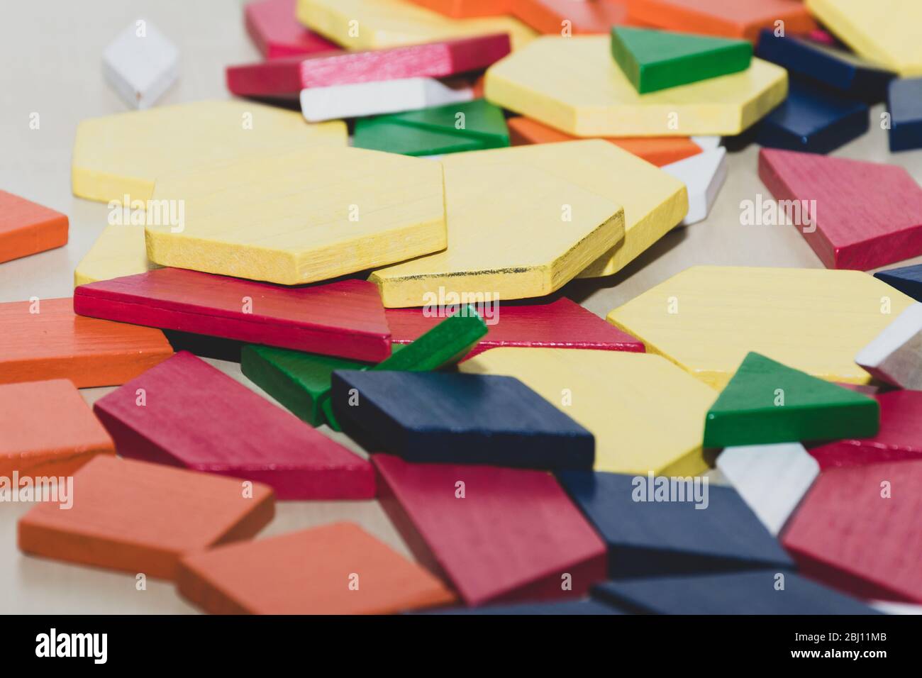 Tangram colorato brillante bambino forma geometrica pezzi puzzle in un mucchio primo piano. Foto Stock