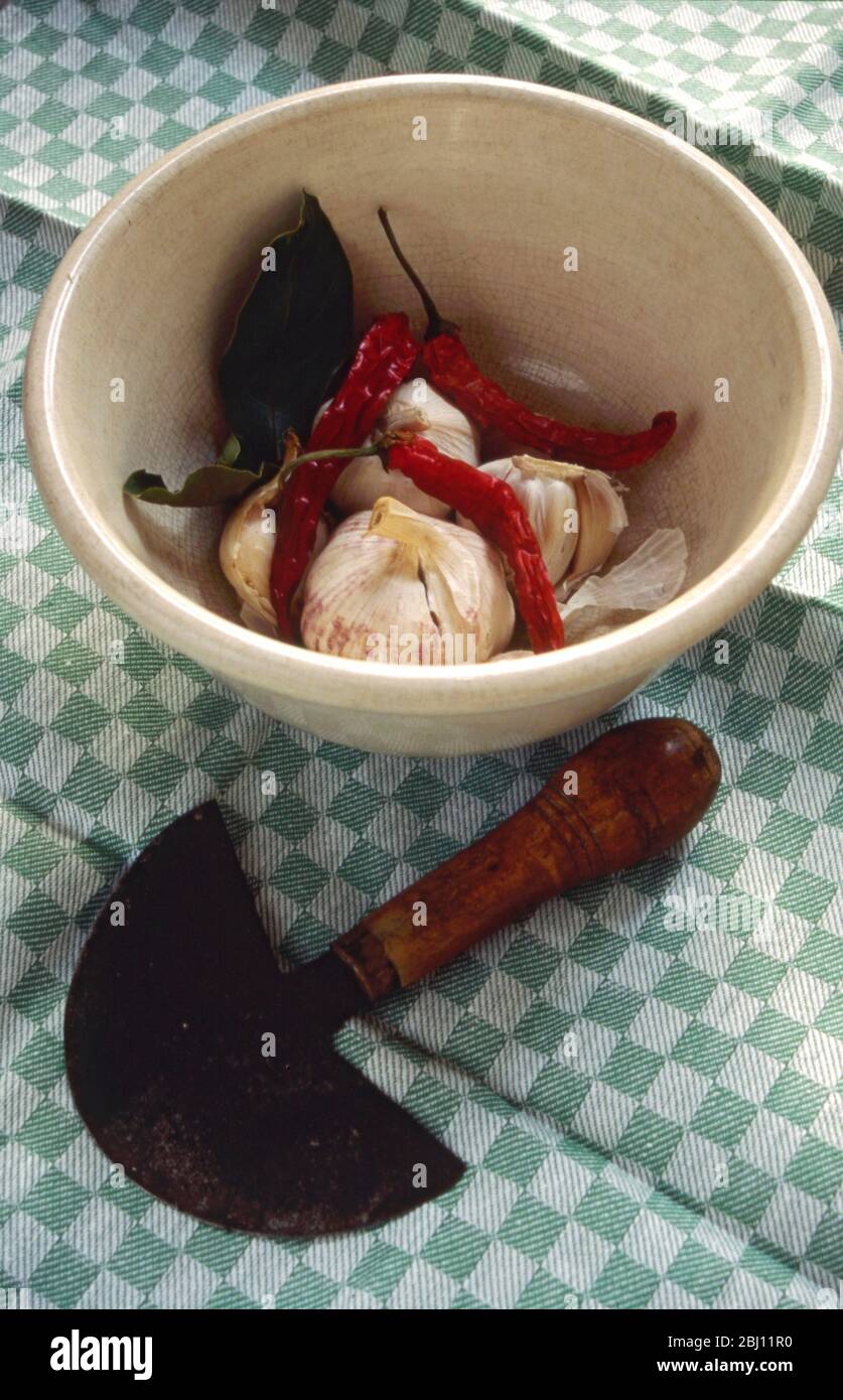 Ingredienti aromatizzanti in vecchio recipiente con smalto cracked - aglio, peperoncino foglia di alloro - Foto Stock