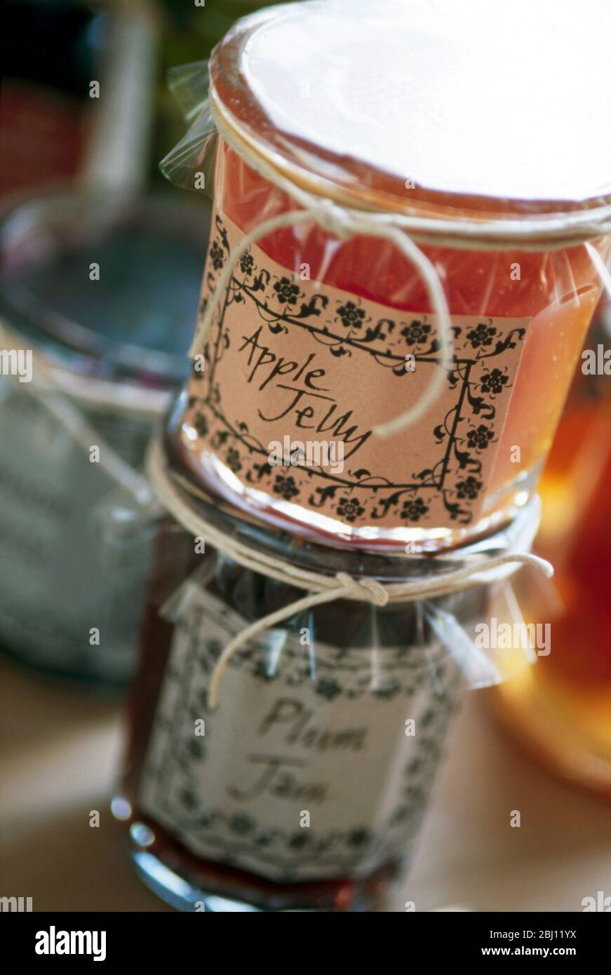 Raccolta di vasetti di gelatine e marmellate di frutta confezionati decorativamente - Foto Stock