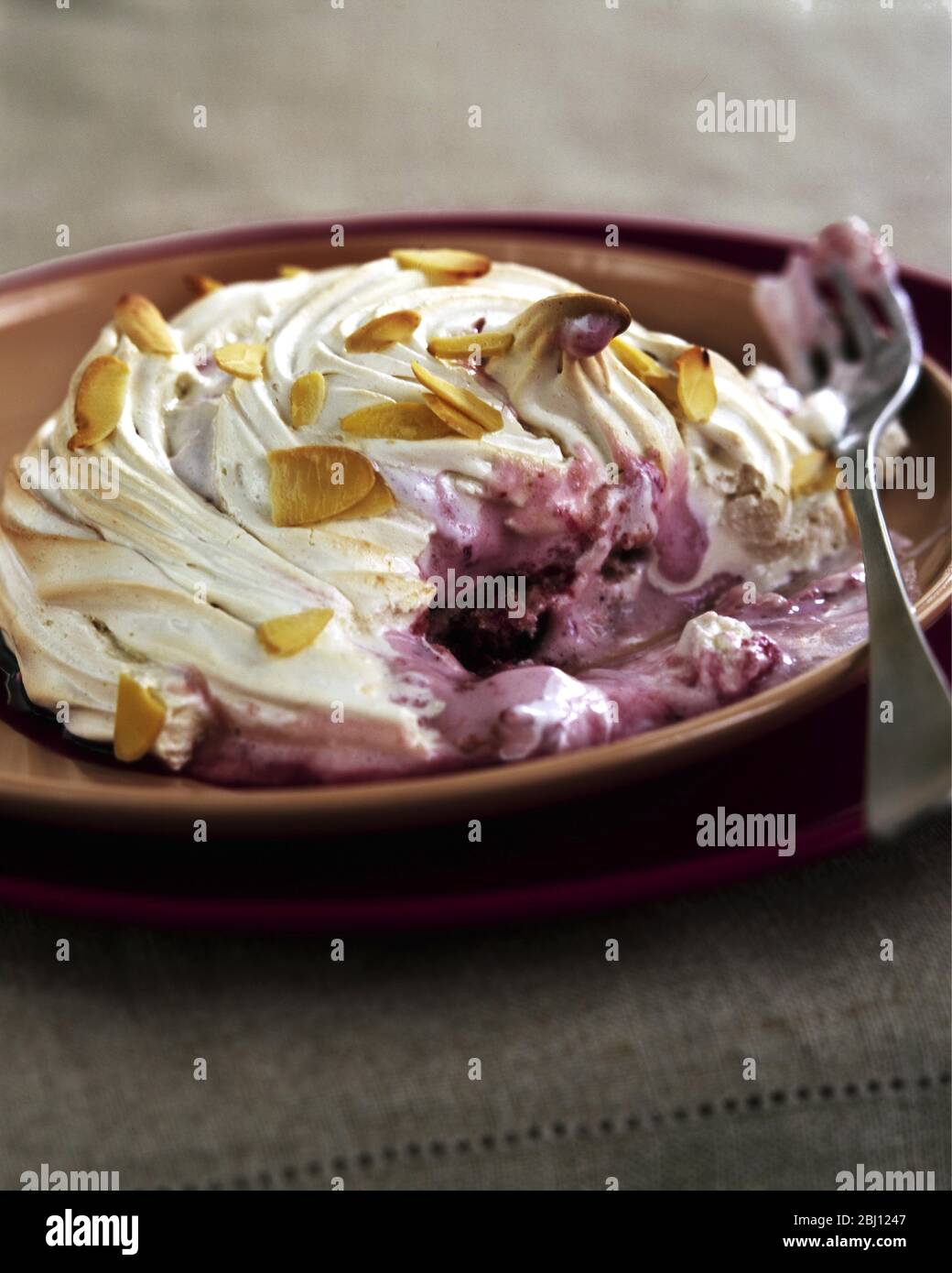 Alaska al forno - meringa su gelato e frutta cotta nel forno caldo - Foto Stock