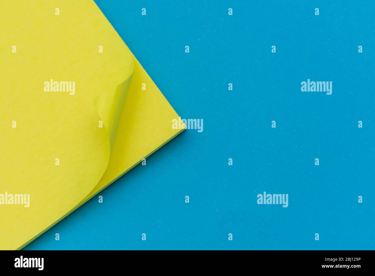 Giallo brillante pubblicato nota su sfondo blu chiaro piatto per l'istruzione o organizzazione aziendale e i concetti promemoria. Foto Stock