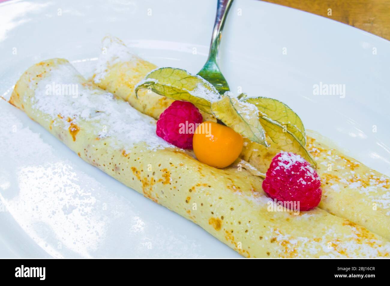 crepes ripieno di cioccolato e bacche con fragole selvatiche e gooseberi di capo Foto Stock