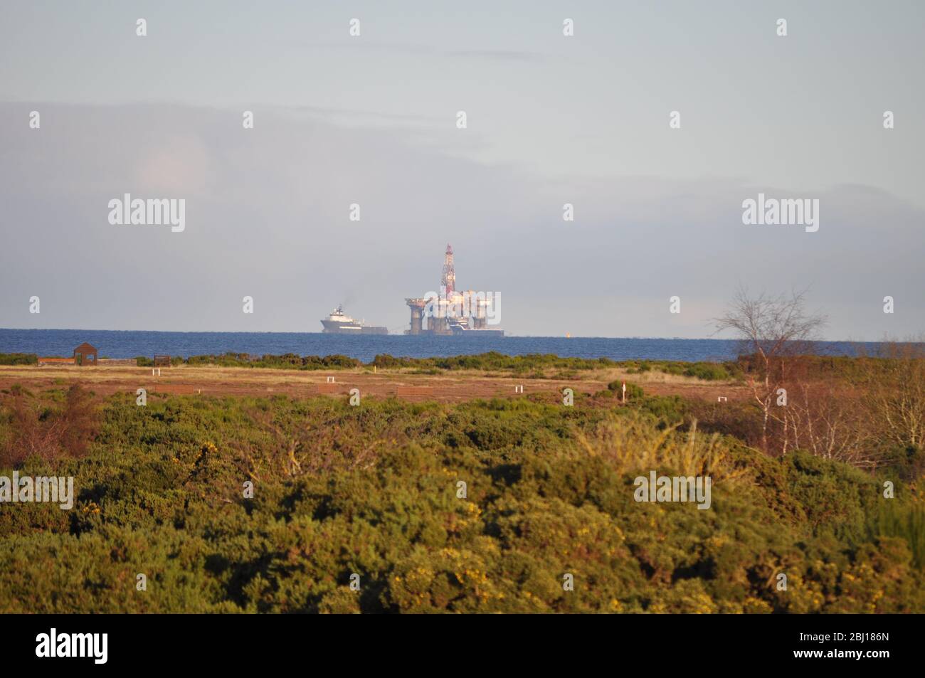 Vista sul mare sulla strada da Fort George a Nairn, Inverness-Shire Scotland. Tug sta trainando un carro di perforazione al Cromarty Firth Foto Stock