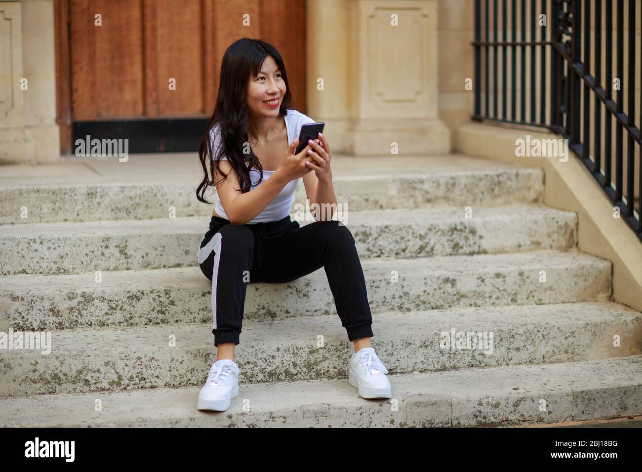 una giovane signora cinese con il suo telefono Foto Stock