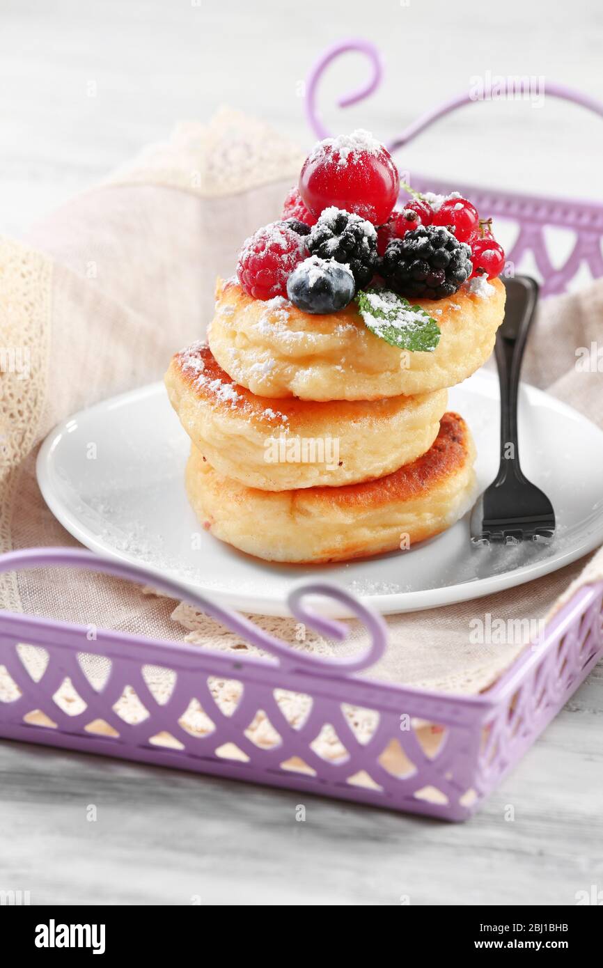 Frittelle di formaggio casolare con frutti di bosco in piatto, primo piano Foto Stock
