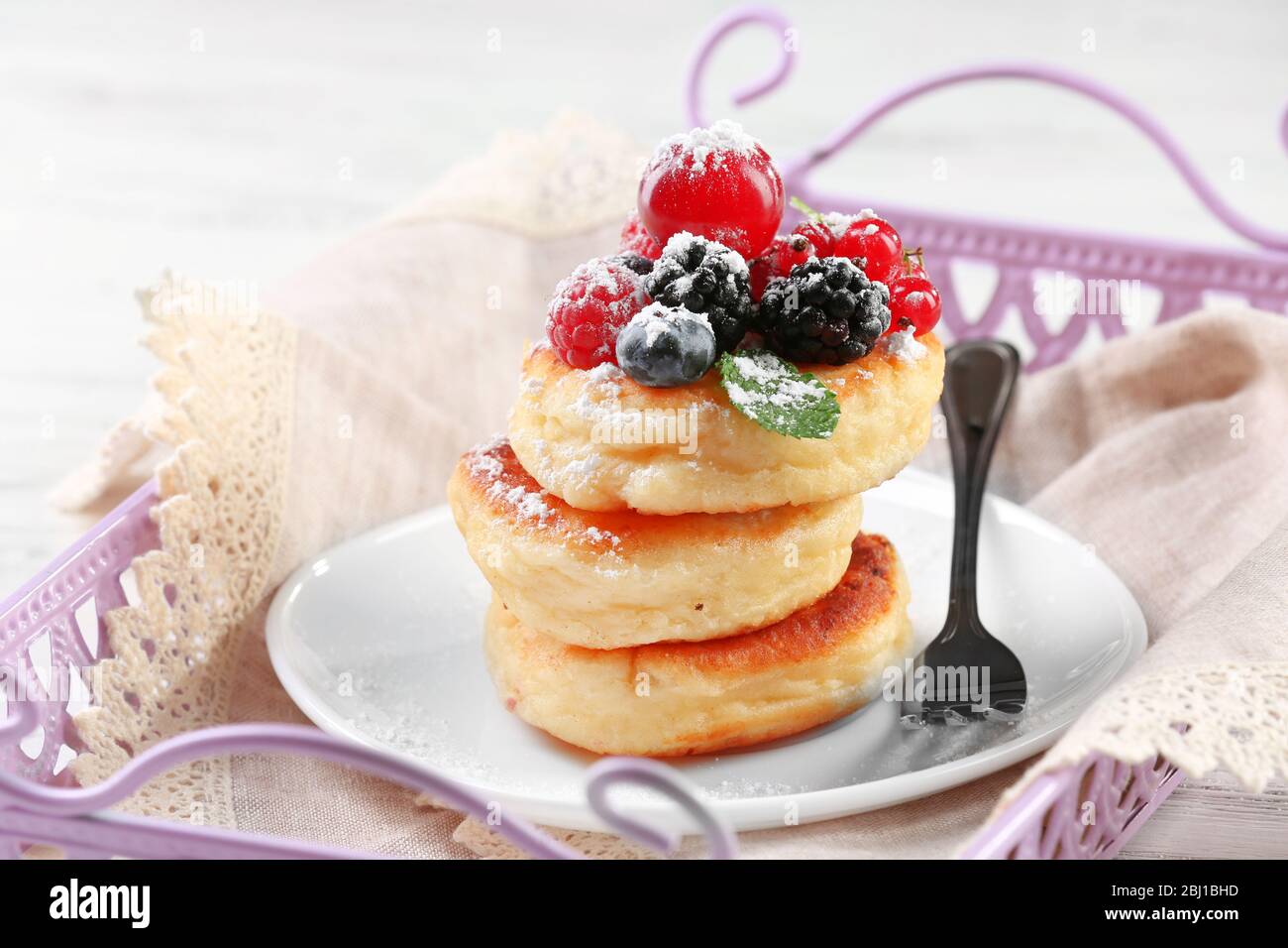 Frittelle di formaggio casolare con frutti di bosco in piatto, primo piano Foto Stock