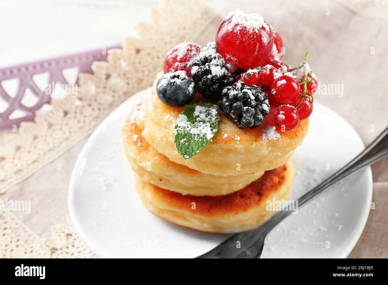 Frittelle di formaggio casolare con frutti di bosco in piatto, primo piano Foto Stock
