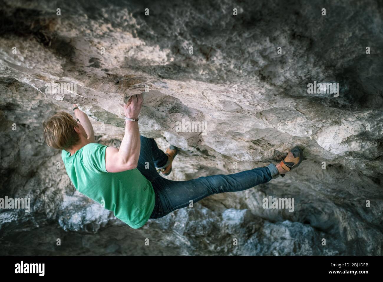 L'uomo sta facendo un masso a Czarcie Schronisko. Bouldering nella roccia. La Cracow di Upland - Czestochowa, Góry Towarne, Polska Foto Stock