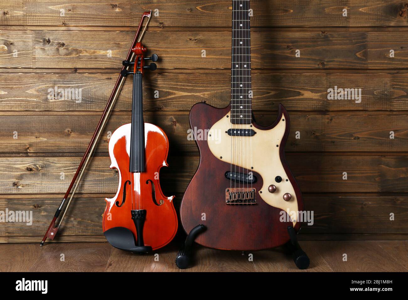 Elettrico e violino su sfondo legno Foto Stock