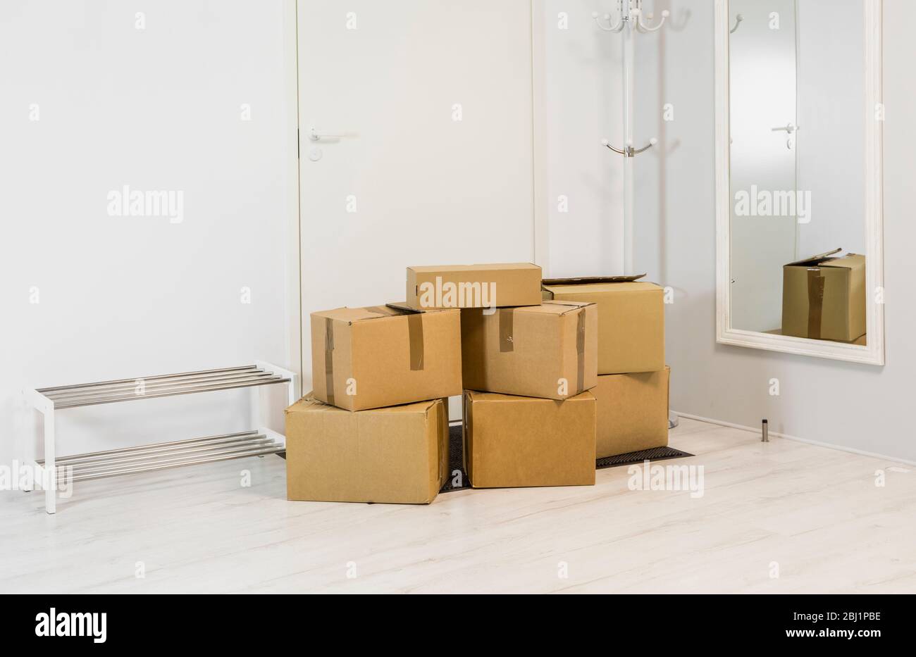 Pile di scatole di cartone in bianco minimalista corridoio casa. Molto spazio per il testo. Foto Stock