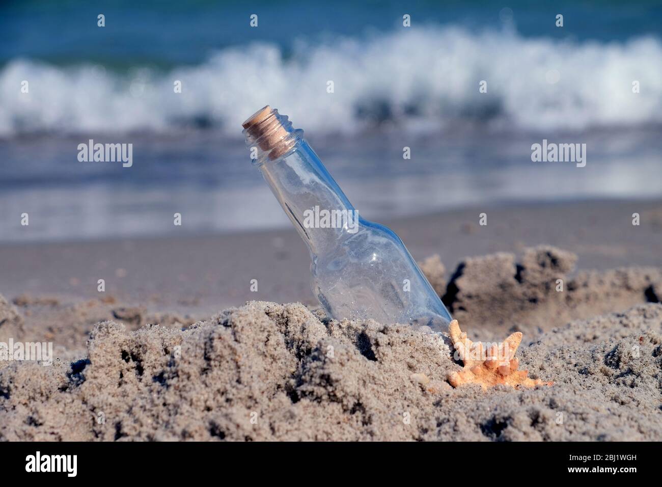 Messaggio in bottiglia su sabbia su fondo mare Foto Stock