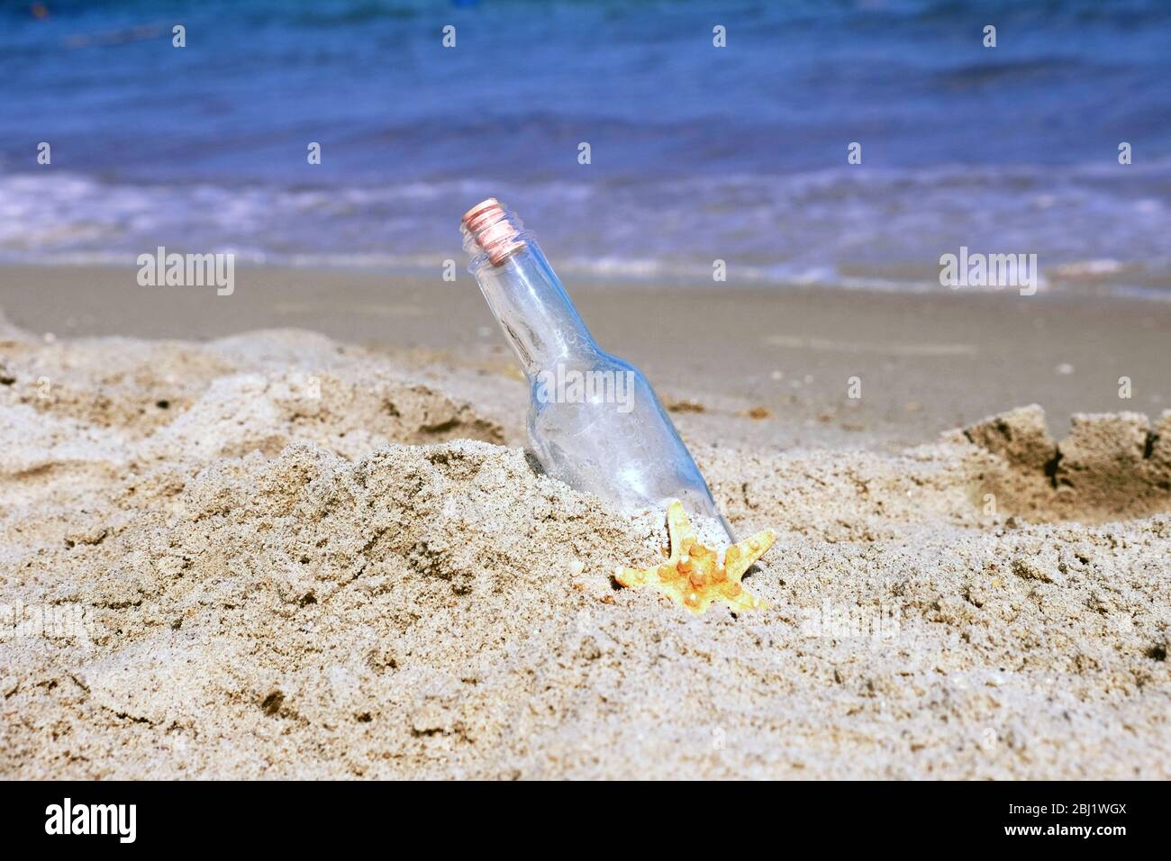 Messaggio in bottiglia su sabbia su fondo mare Foto Stock