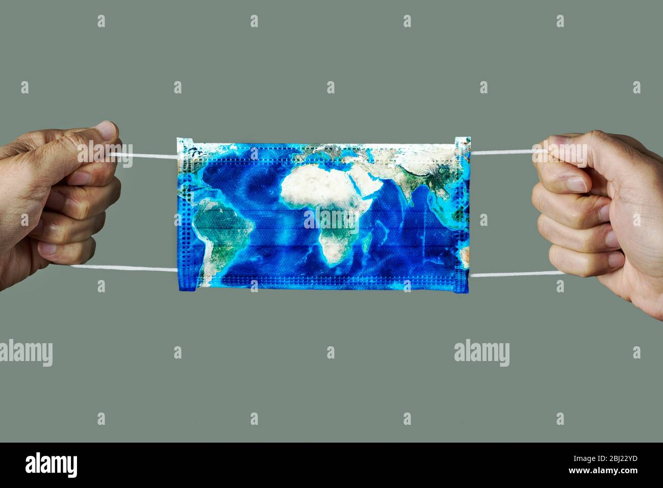 Primo piano di uomo con una maschera chirurgica modellata con una mappa del mondo (fornita dalla NASA) su uno sfondo grigio Foto Stock