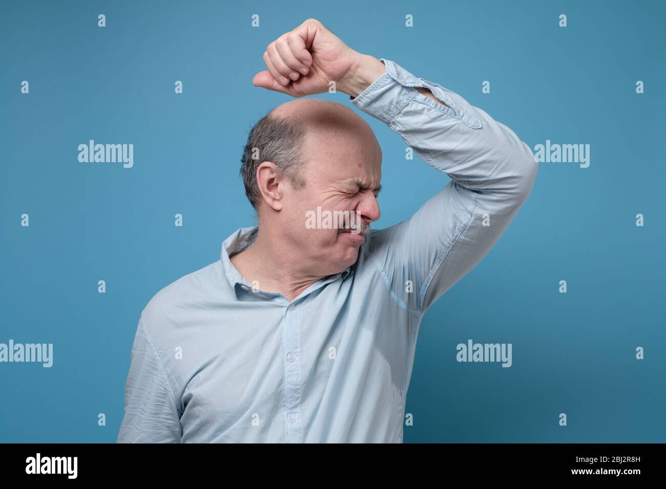 Uomo ispanico anziano con camicia sudata a causa di iperidrosi o tempo caldo Foto stock Alamy