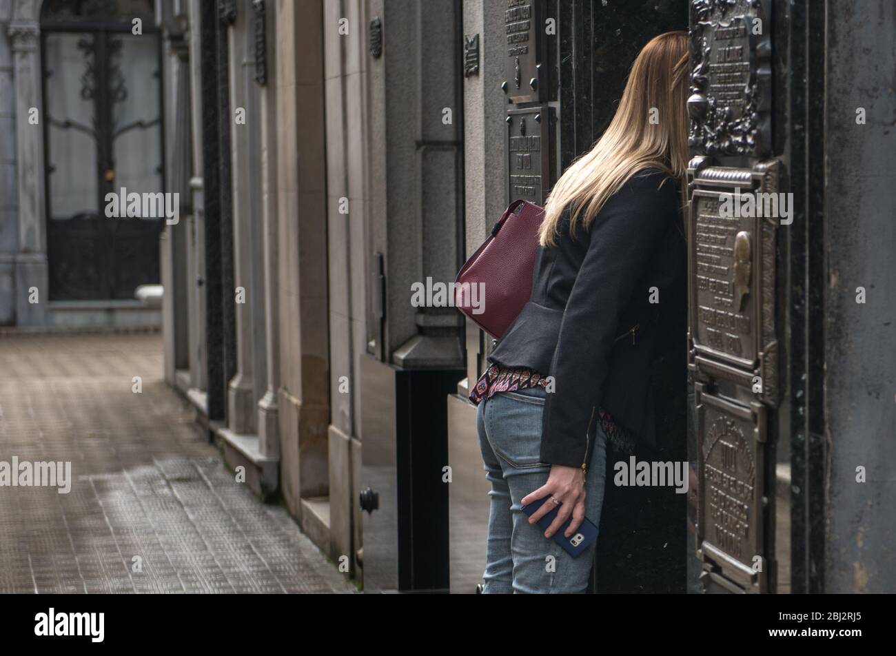 Donna che guarda e cerca all'interno della tomba di evita Peron. Foto Stock