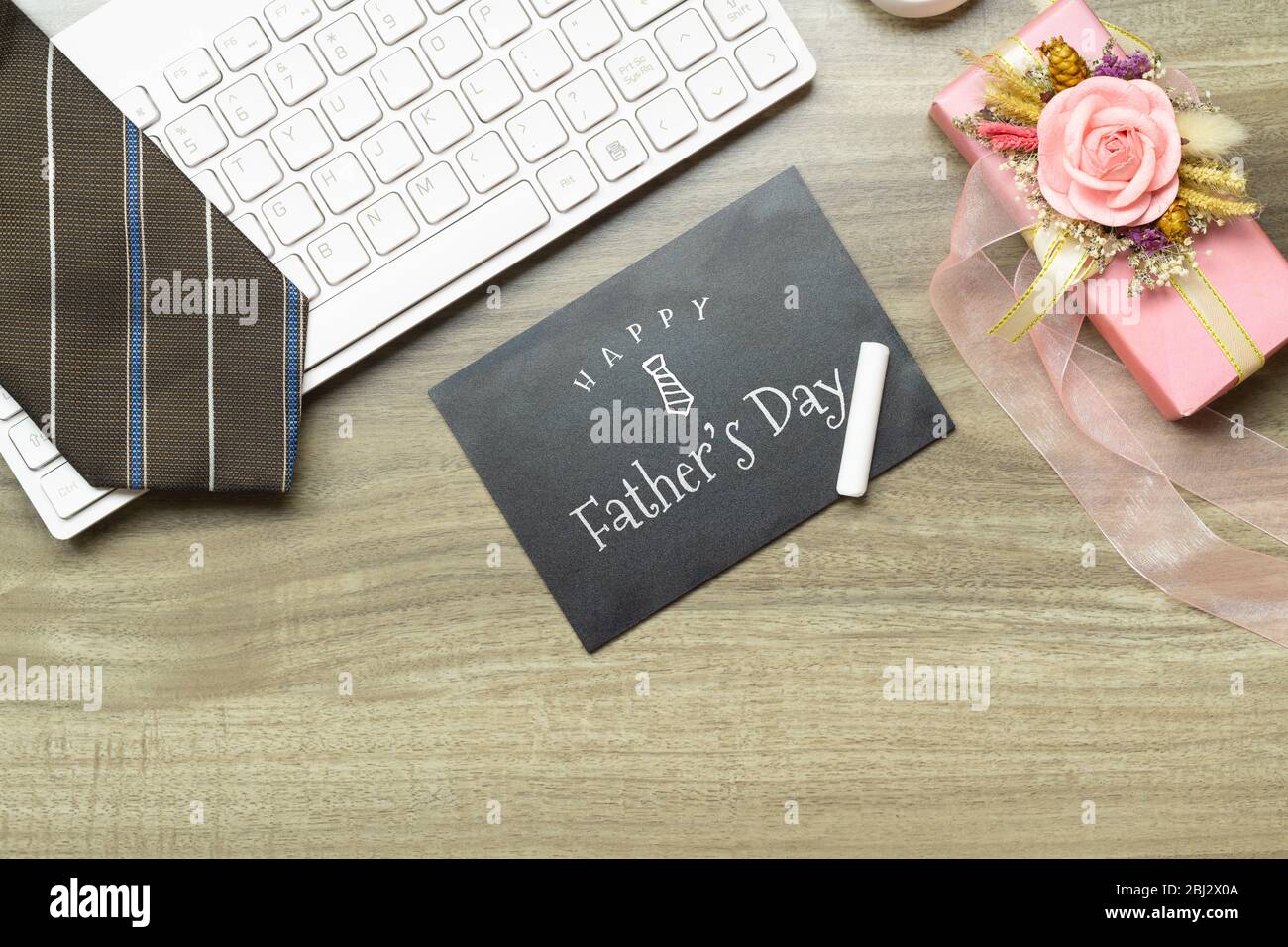 Messaggio del giorno di buon padre sulla lavagna. Composizione a base piatta su scrivania con tastiera per computer, cravatta e boex regalo. Foto Stock