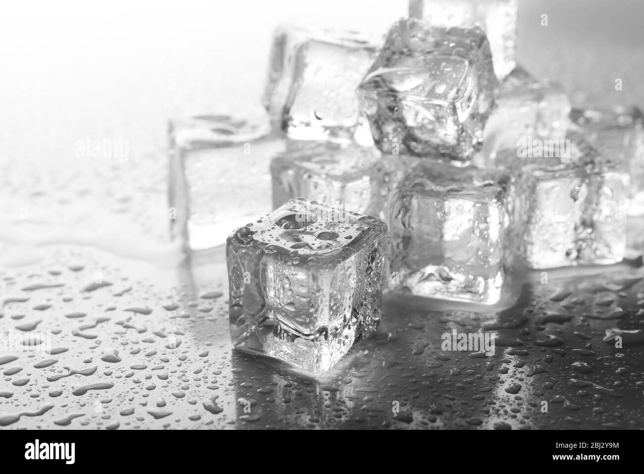 Fusione dei cubetti di ghiaccio su sfondo grigio, primo piano Foto Stock