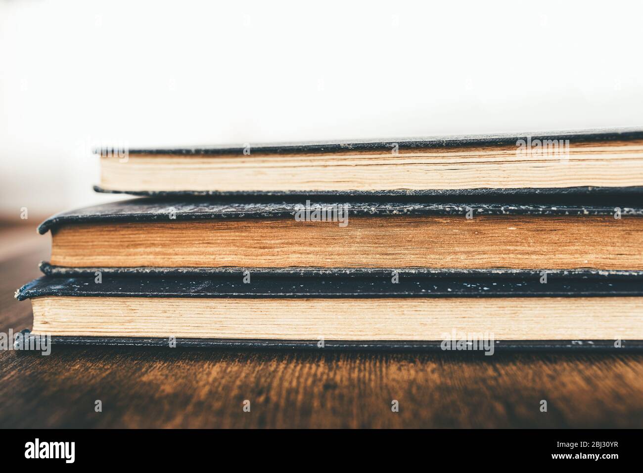 primo piano di una pila di libri d'epoca su un tavolo rustico in legno Foto Stock