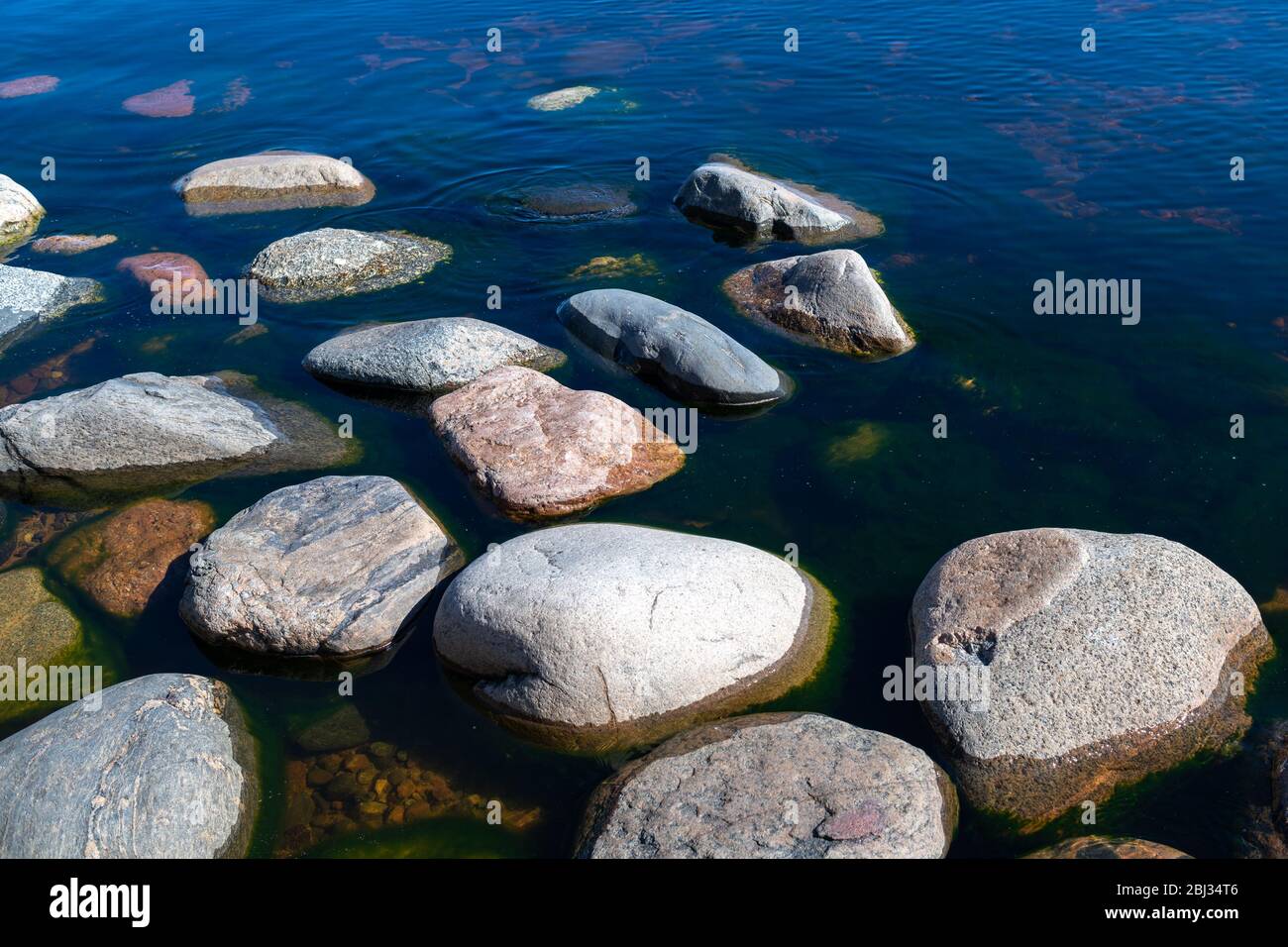 Pietre in acqua limpida e blu lago. Lago Ladoga, Russia. Foto Stock