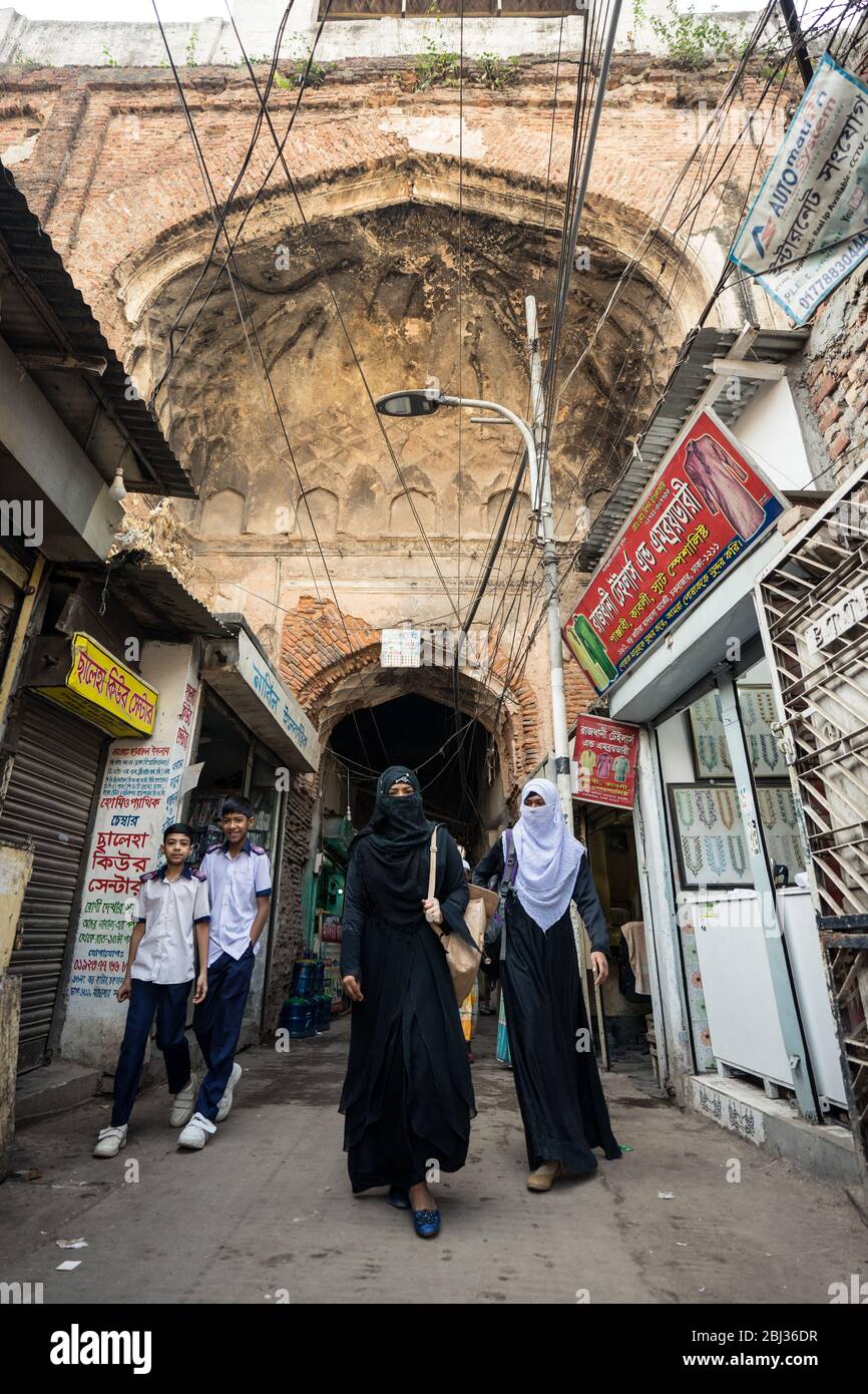Dhaka / Bangladesh - 14 gennaio 2019: Donne musulmane che indossano abiti tradizionali musulmani a piedi sotto il bel vecchio arco nella storica vecchia Dhaka Foto Stock
