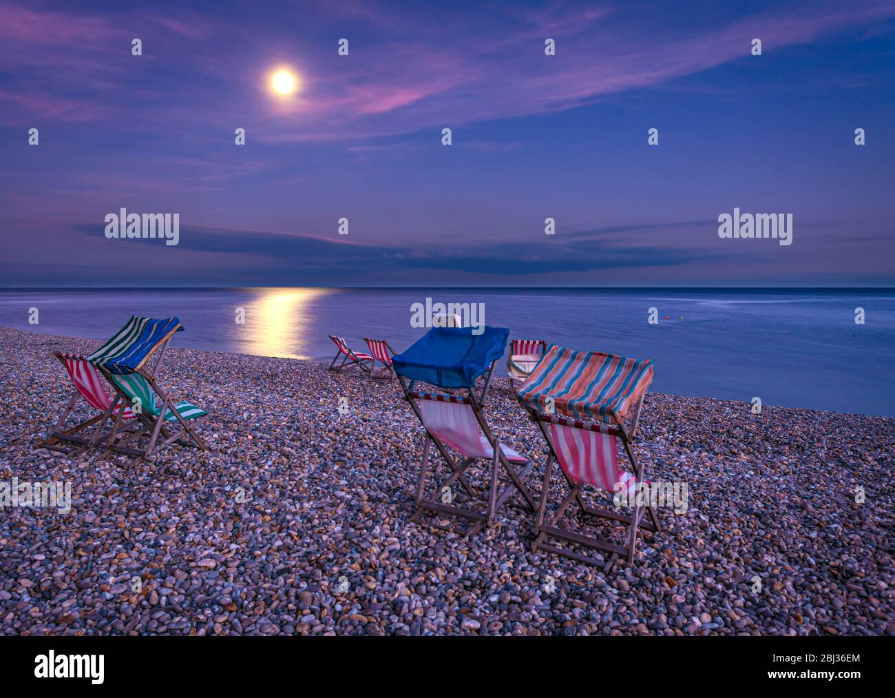 Sedie a sdraio sulla spiaggia al chiaro di luna. Foto Stock